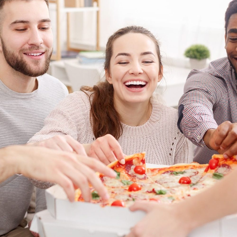 friends-taking-slices-of-hot-pizza-from-cardboard-XD65K9Y-min.jpg